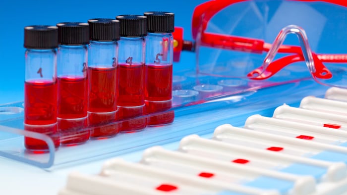 Array of blood samples for microscopy and biopsy tissue on blue gradient background