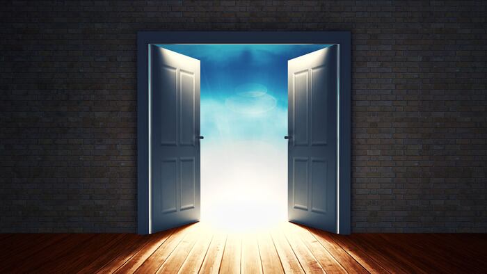Open big door on wall against sunset sky