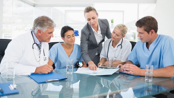 Team of doctors and businesswoman having a meeting in medical office