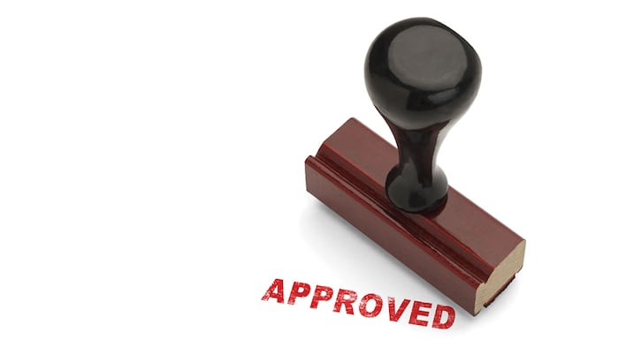 Red Approved Stamp with Wooden handle Rubber Stamper Isolated on White Background.