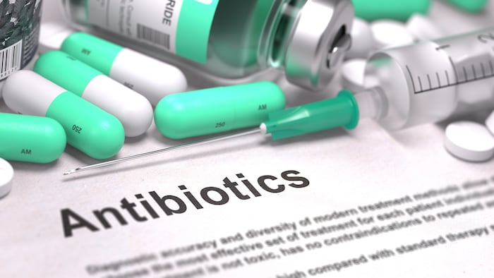 Antibiotics. Medical Report with Composition of Medicaments - LIght Green Pills, Injections and Syringe. Blurred Background with Selective Focus.