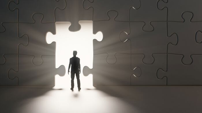 Man walking through a break in a jig-saw puzzle wall - 3D illustration