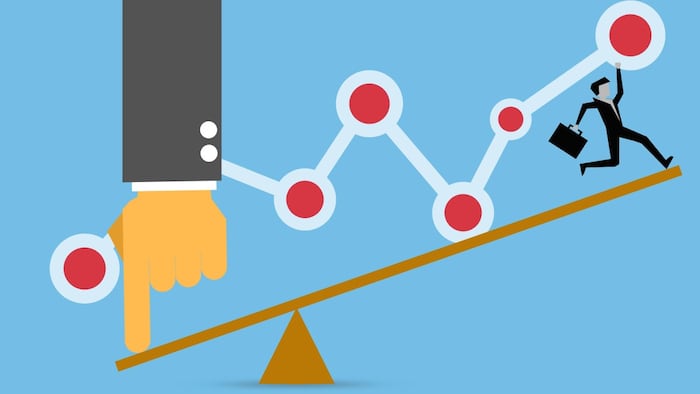 Finger pushing seesaw to help businessman move up.