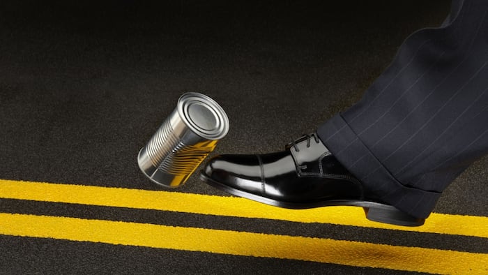 close up of foot kicking can down the road