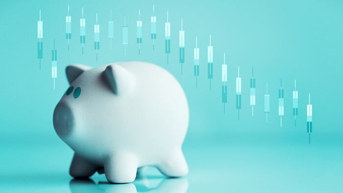 Piggy coin bank and stock candlestick chart going down for investments and savings loss
