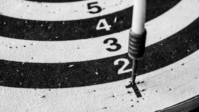 Old dart target with arrows.