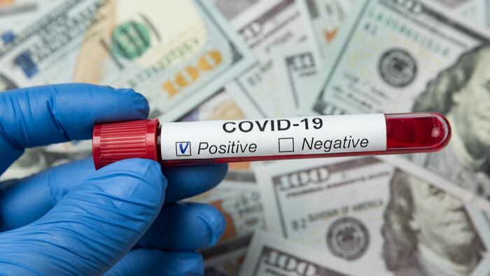 Test tubes with blood sample on coronavirus. Money background. How much is cost analysis on Covid-19. S