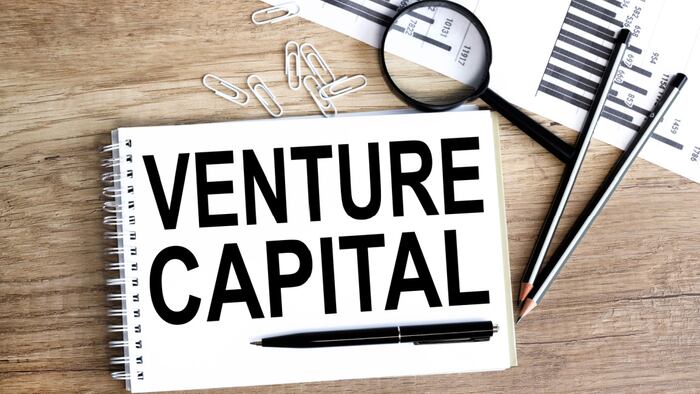 venture capital, text on white paper on wood background