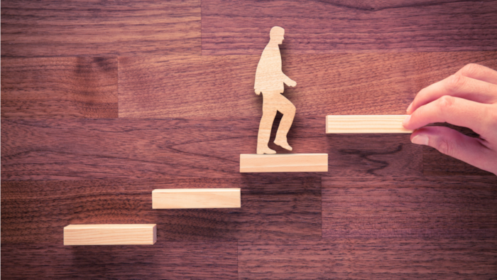 Silhouette of a man climbing steps, representing growth