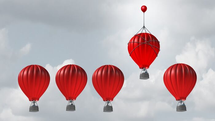 Red hot air balloons in a line against the sky, one red hot air balloon higher than the rest