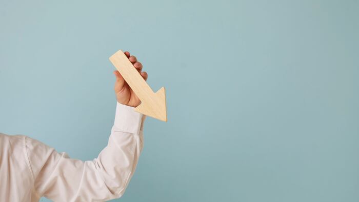 Man holding graph chart arrow that's pointing down