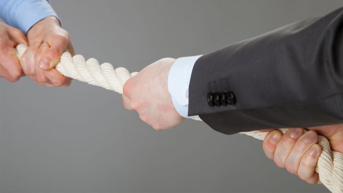 Two businessmen pulling a rope, closeup shot tug of war