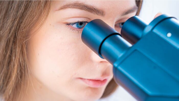 Scientist analyzing microscope slide at laboratory