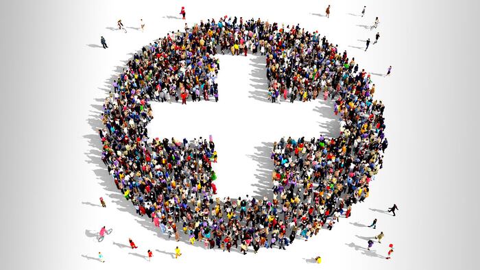 Large group of people seen from above gathered together in the shape of a plus sign