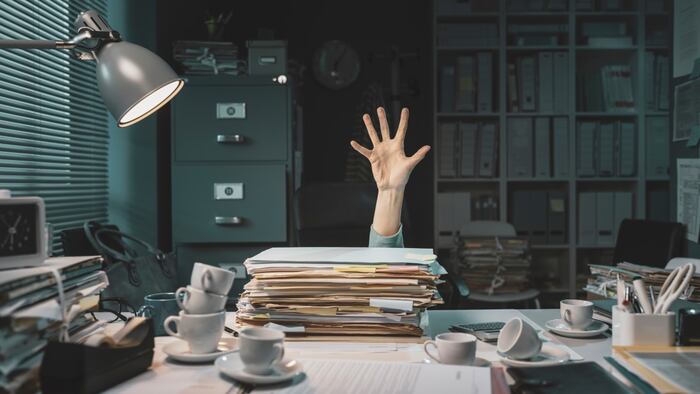 Desperate office worker overwhelmed with paperwork, she is asking help with her hand