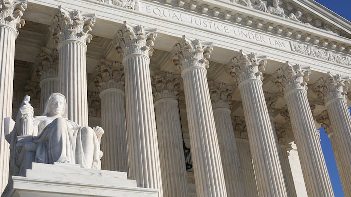 US Supreme court building with 1st statue on left