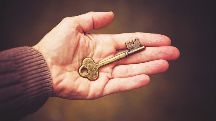 a hand with an antique skeleton key toned with a retro vintage filter instagram app or action effect