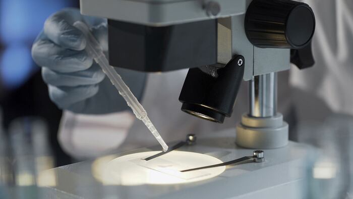 Research analyst adding reagent to drug to keep tracking chemical reaction - Image