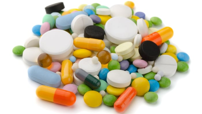 Pile of various colorful pills isolated on white