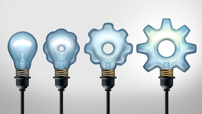 Business development idea and developing industry success through creative invention as a light bulb evolving to a gear shape as a 3D illustration.