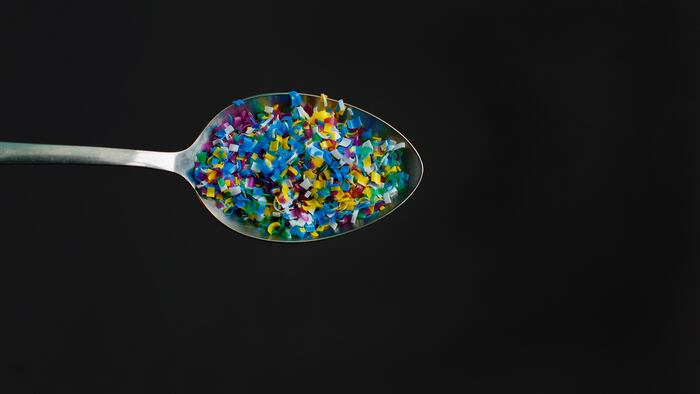 Microplastic in a glass of water on black background. Microplastic problem. Threat to human health and the environment. Dangerous additives. Toxic substances.