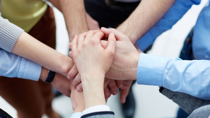 Business partners hands on top of each other symbolizing companionship