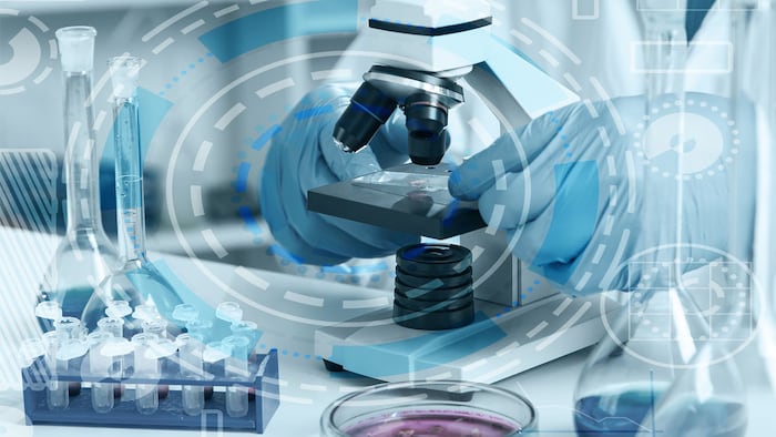 woman in a laboratory microscope with microscope slide in hand.toned image.