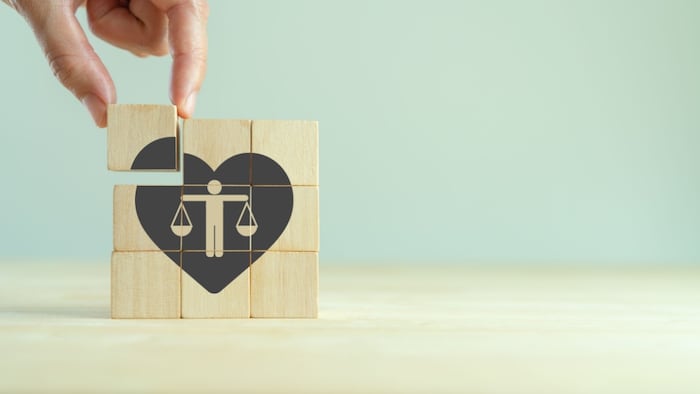 Ethical corporate culture concept. Ethics inside human heart. Business integrity and moral. Placing wooden cubes with ethics inside a heart on smart background. Sustainable business development.