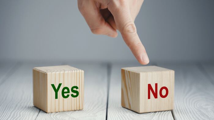 a wooded block with "yes" and a wooden block with "no". Finger points to "no" block.
