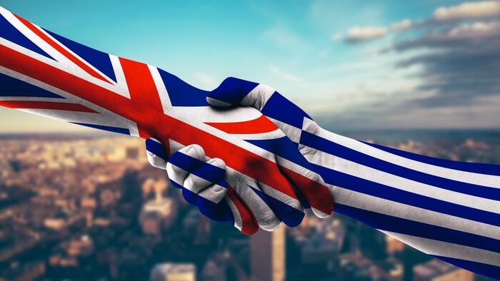 Handshake with flags of UK and Greece