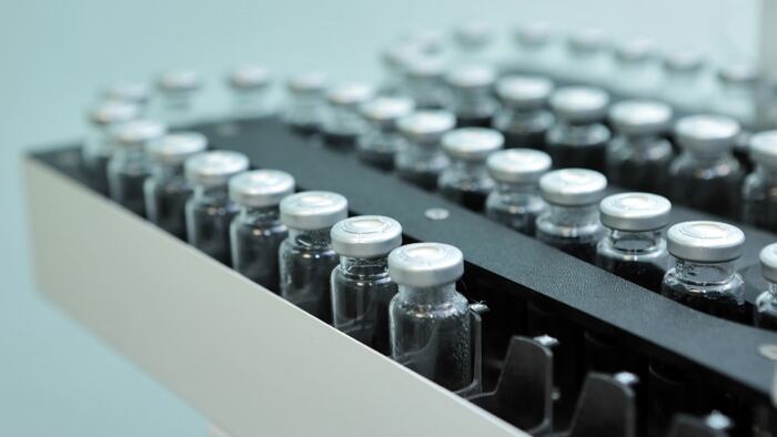 Sterile bottles and ampoules on the dispensing line.Sealed ampoules with medicine.Sterile capsules for injection. Bottles on the bottling line of the pharmaceutical plant.