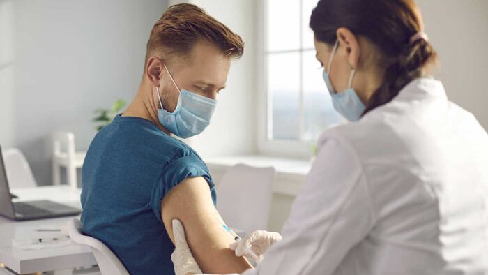 Man receiving an injection from healthcare practitioner