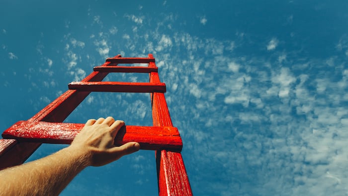 Development Attainment Motivation Career Growth Concept. Mans Hand Reaching For Red Ladder Leading To A Blue Sky