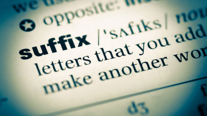 Close up of old English dictionary page with word suffix