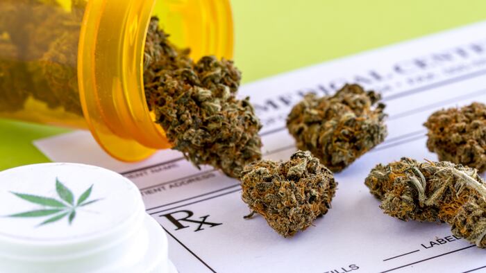 marijuana spilling out of prescription pill bottle on prescription pad