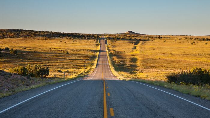 Bumpy road crossing plains at sunset