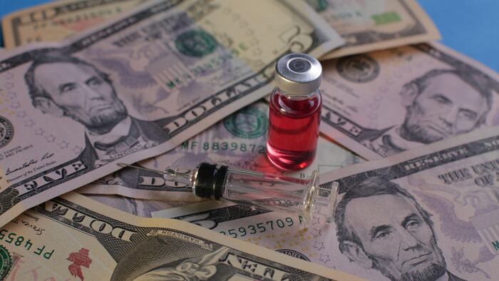 Syringe vial on a background of American dollars