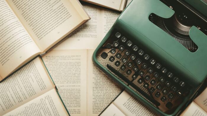 Top view of vintage typewriter with books and copy space