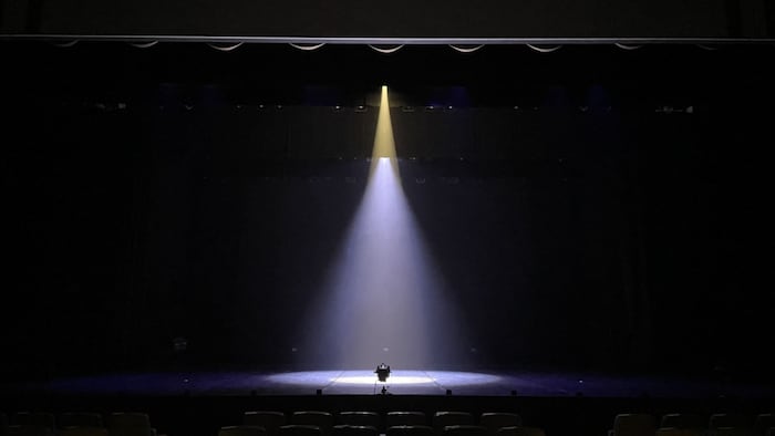 empty dark stage with a spotlight on the center