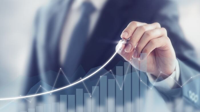 Businessman drawing graph upwards