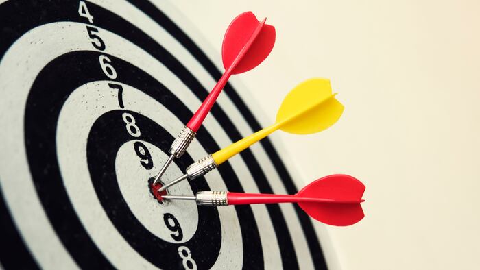 Side view of a dartboard with three darts in the bull's eye. Well-aimed dart throwing. Triple bull's-eye hit. Three well-made dart throws. Successful attempts. To attempt difficult task. Darts ace