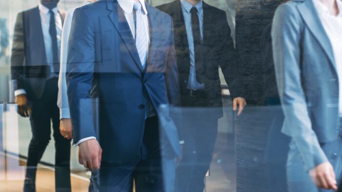 Diverse Team of Delegates/ Lawyers Led by Woman Confidently Marches Through the Corporate Building Hallway. Multicultural Crowd Of Resolute Business People in Stylish Marble and Glass Offices