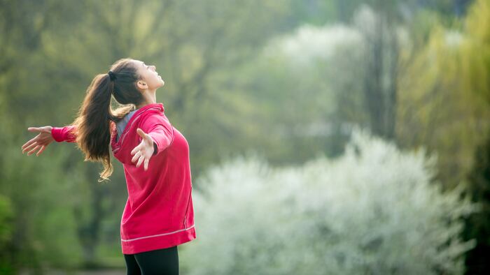 Profile portrait of happy sporty woman relaxing in park. Joyful female model breathing fresh air outdoors. Healthy active lifestyle concept. Copy space - Image
