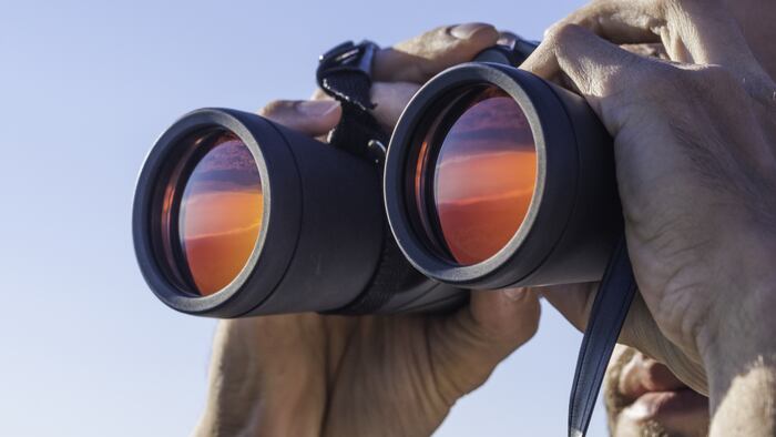 A man looking through the binoculars