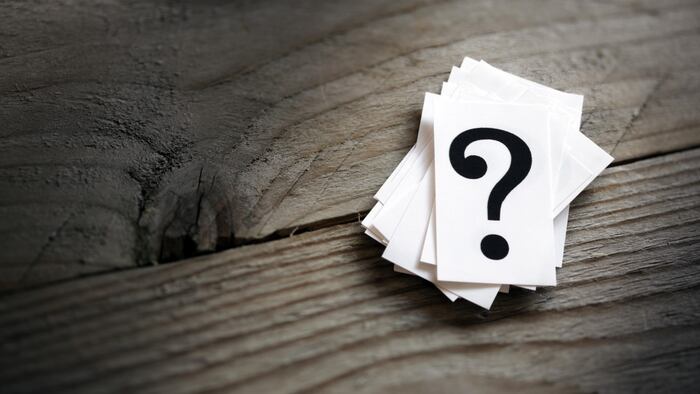 Stack of question marks on wood table