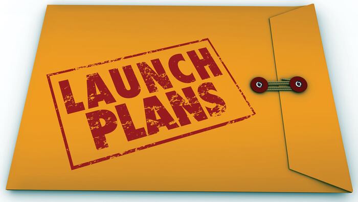 Launch Plans words stamped in red ink on yellow envelope offering advice, information