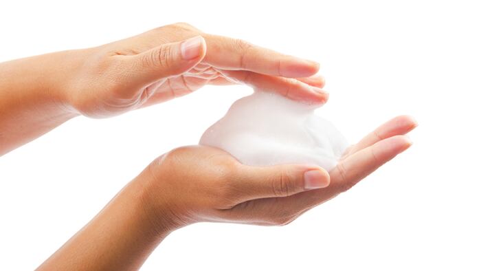 close up foam in two hand isolated on white background. - Image