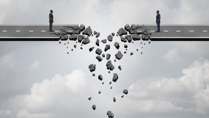 Business deal failure concept as two businessmen on a road bridge that is breaking down and disconnecting