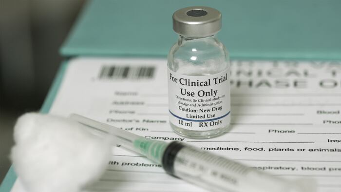 Clinical trial medicine, for the covid-19 coronavirus, on clipboard