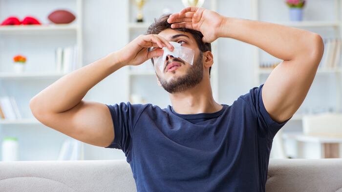 Young man recovering healing at home after plastic surgery nose